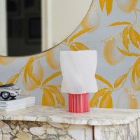 Pale blue wallpaper with a mustard yellow lemon branch and leaf pattern