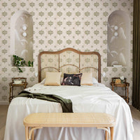 Maximalist coastal style bedroom interior with palm leaf wallpaper as well as removable vintage Italian tile wallpaper accent wall behind rattan bed