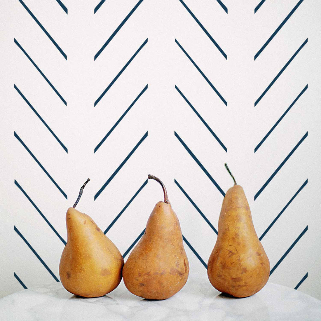 Navy blue herringbone design removable wallpaper in coastal kitchen interior with marble countertop