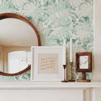 Mint color tropical palm leaves removable wallpaper in neutral bohemian style living room interior with round wooden mirror and framed gallery wall art