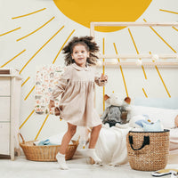 Whimsical sun design wallpaper in bohemian kids room interior