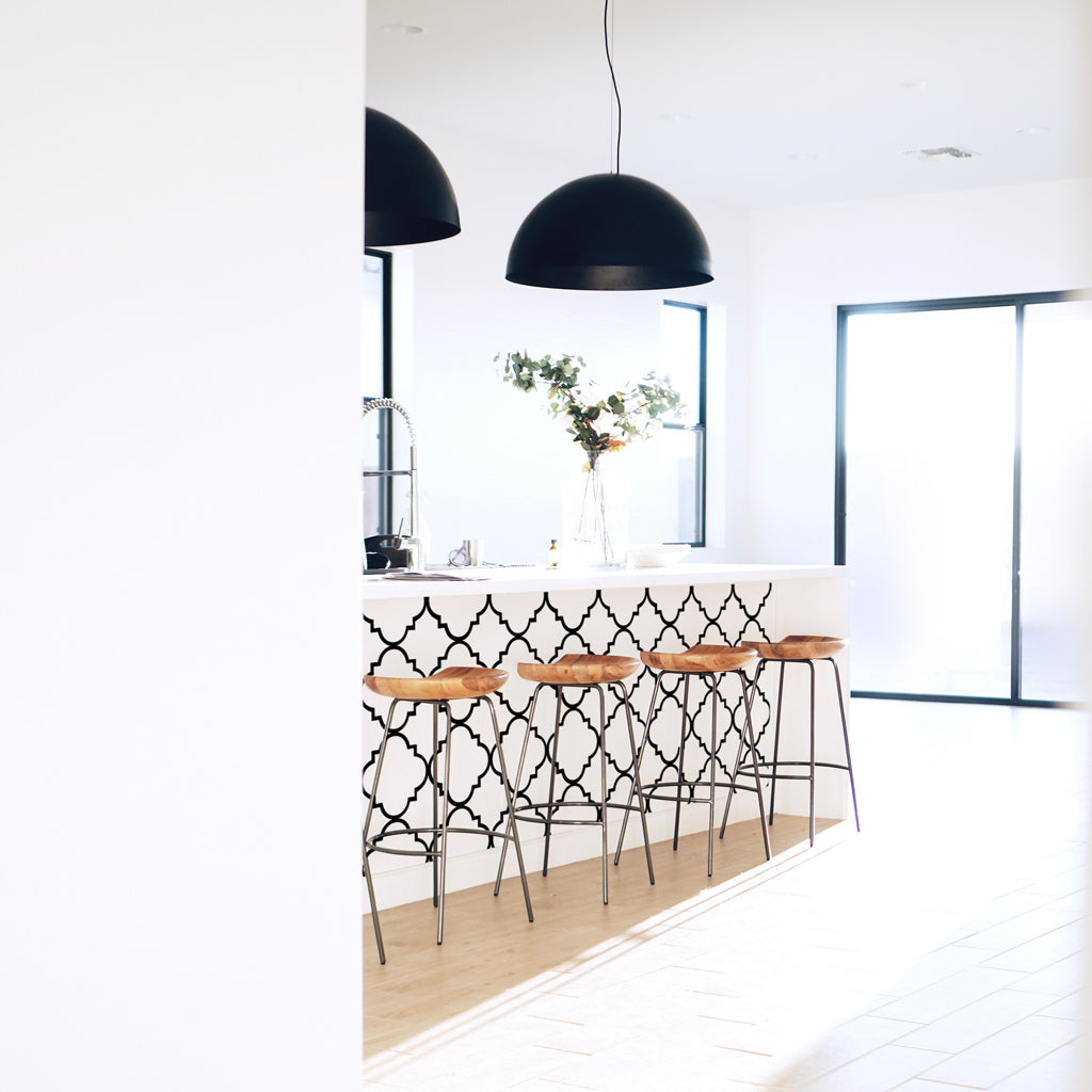 White kitchen interior with moroccan design wallpaper on kitchen island