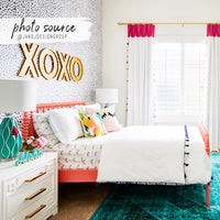 eclectic girls bedroom interior with navy and white tiny spots pattern wallpaper