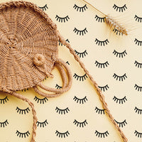 Sleepy eyes removable wallpaper in yellow bohemian girl's room interior with rattan furniture
