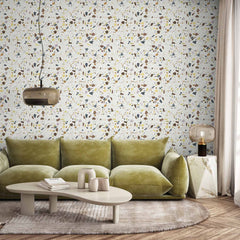 White wallpaper with multicolor terrazzo fleck pattern in mustard, mint, and gray