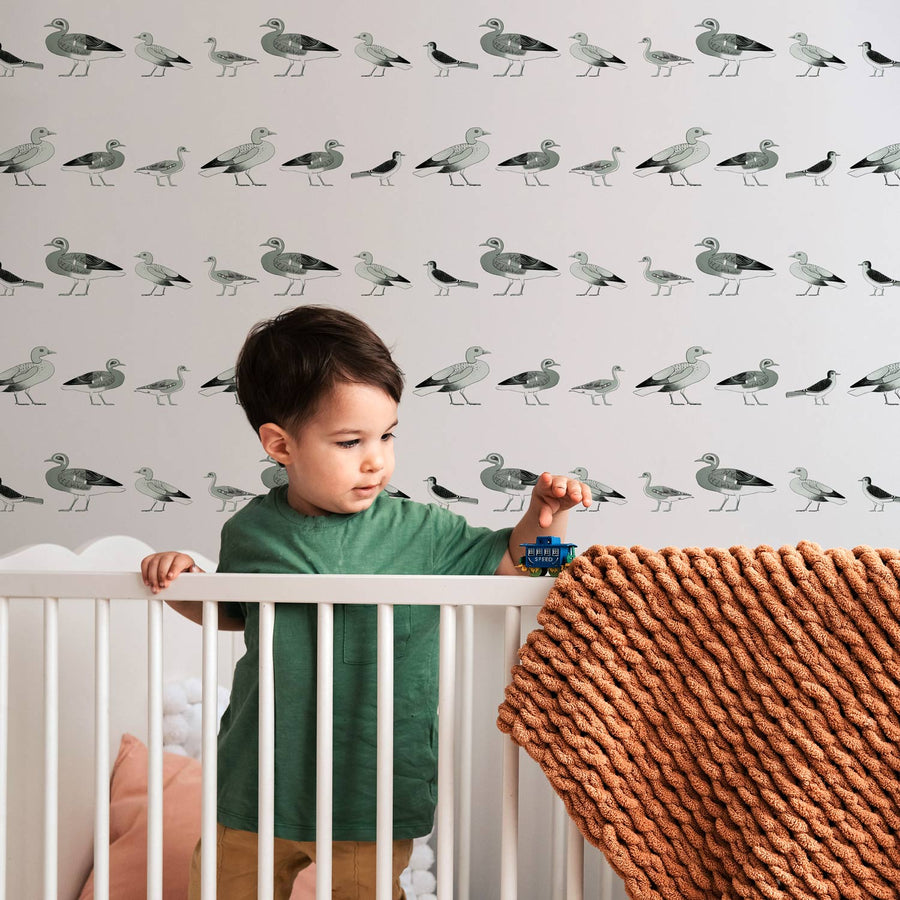 Eclectic vintage duck design wallpaper in white boys nursery interior