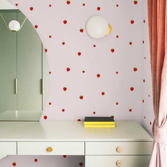 Pale pink wallpaper with a scattered tiny red strawberry pattern