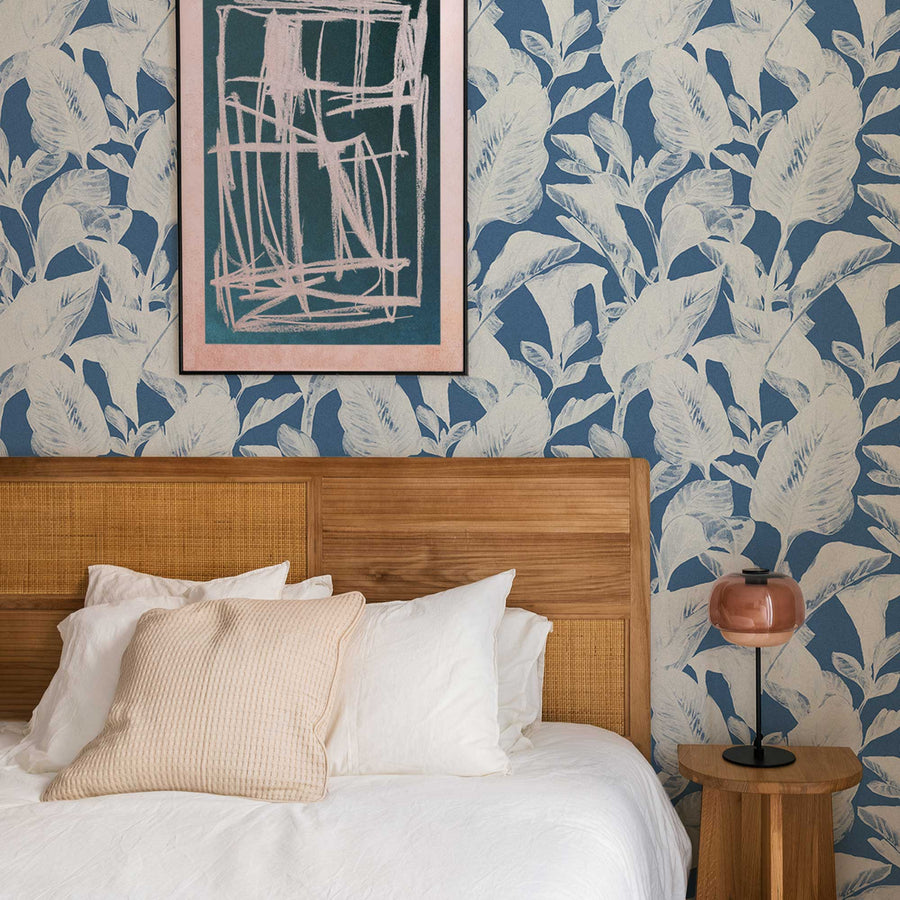bohemian design bedroom interior with blue tropical leaf print wallpaper