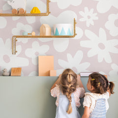Blush pink wall mural with white daisy flower silhouette pattern