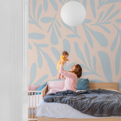 Pale pink wall mural with soft blue abstract leaf branch pattern