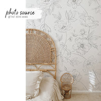delicate black and white floral print wallpaper with bohemian rattan bed