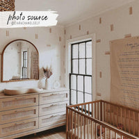 minimal light beige nursery interior with brush strokes print wallpaper